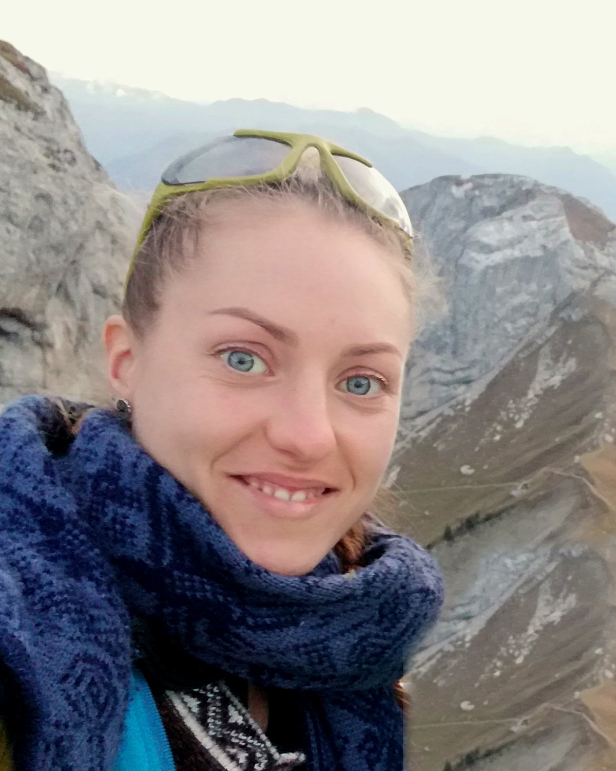 Miriam Emilia lächelt in die Kamera, hinter ihr Berggipfel im Herbstlicht